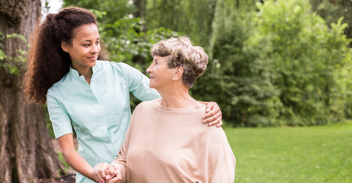 Pflegerin legt Hand um ältere Frau